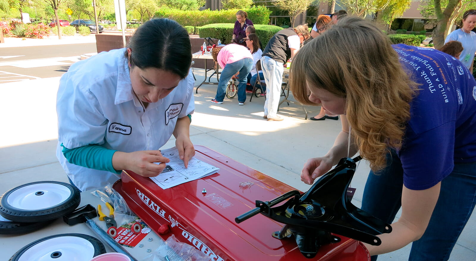 co-workers work on building a tricycle for charity